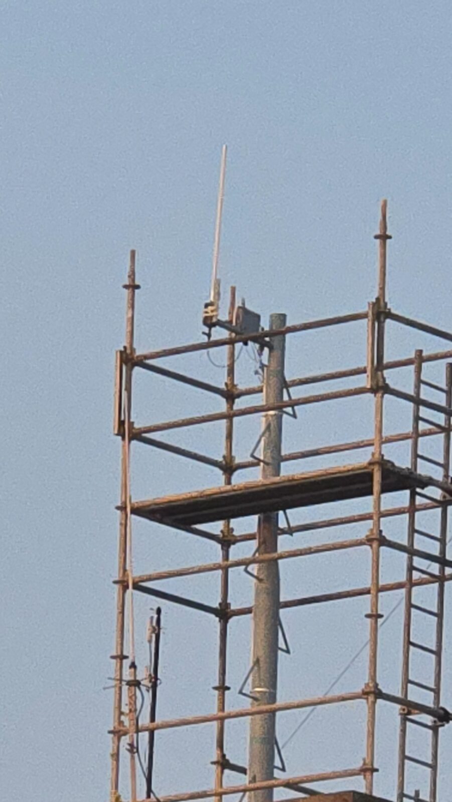 Tall omnidirectional LoRaWAN antenna on construction scaffold tower